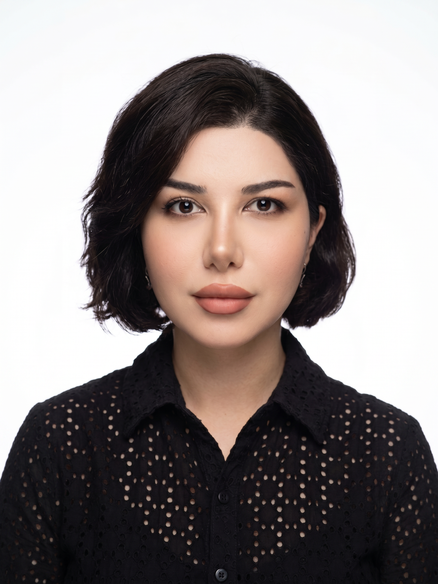 Portrait of a woman with short dark hair wearing a black blouse against a white background.
