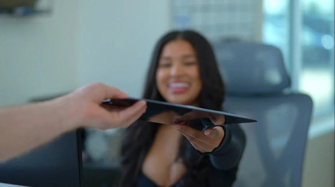 Smiling Revive front desk team member taking a check-in tablet from a patient