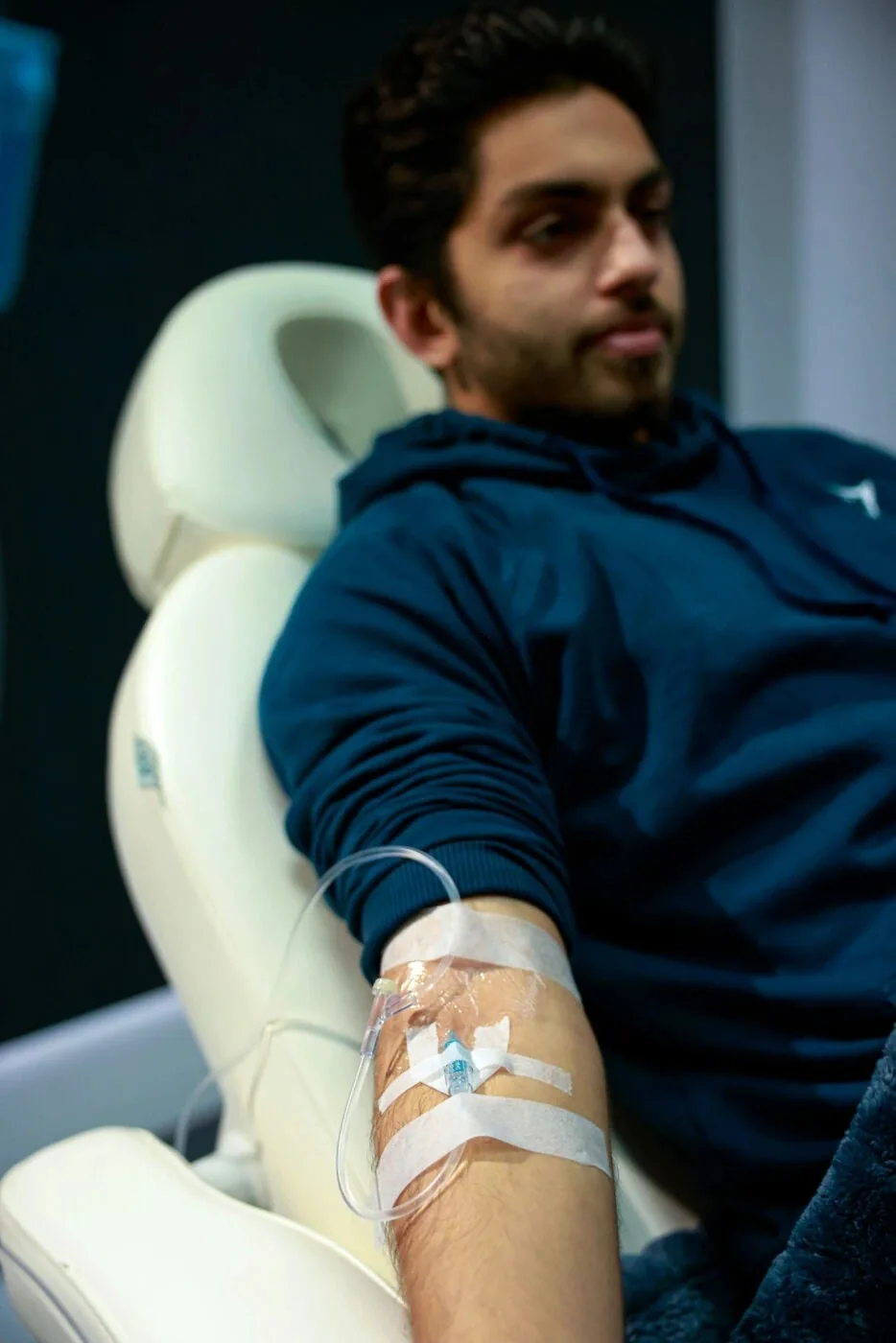 Patient seated in a Revive IV lounge chair with an IV line in his arm